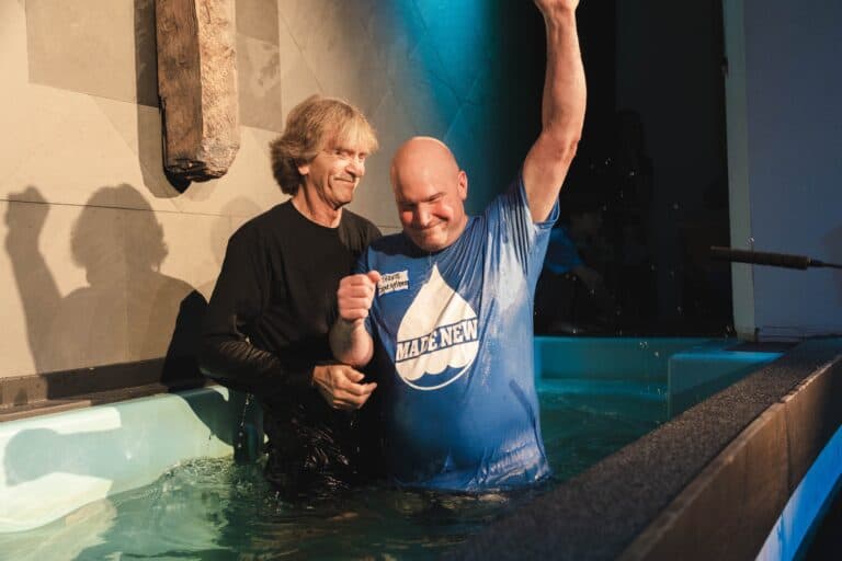 Two men celebrating a transformed life during water baptism at Westgate Chapel, Edmonds, Washington.